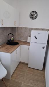 a kitchen with a white refrigerator and a sink at McShane Studio 1 - Parking in Dudu