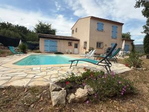 a villa with a swimming pool in front of a house at Villa provençale La Banisté in Saint-Cézaire-sur-Siagne