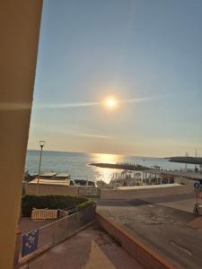 a view of the beach at sunset from a balcony at Casa al mare 2 in Rosignano Solvay
