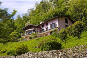 a pink house on a hill with a stone wall at La Florida in Ameno