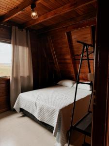 a bedroom with a bed with a wooden ceiling at Chalé Nosso Kadito - Glamping Estrada Real in Itutinga