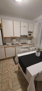 kuchnia z białymi szafkami, stołem i krzesłami w obiekcie Apartment 2 Feistriz in Rosental 9181 w mieście Feistritz im Rosental
