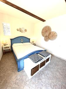 una camera da letto con un letto blu in una stanza di bilocale in centro a capoliveri a Capoliveri Altre 10 foto