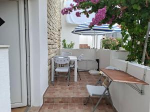 a patio with a table and chairs and an umbrella at Apartments Panonija in Novalja +10 photos