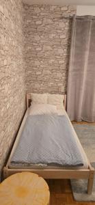 łóżko w pokoju z ceglaną ścianą w obiekcie Apartment 2 Feistriz in Rosental 9181 w mieście Feistritz im Rosental