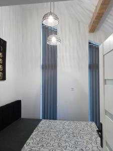1 dormitorio con 2 lámparas de araña y 1 cama en Panorama Resort, en Radocza