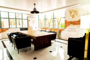 a dining room with a wooden table and chairs at Dancenter Sukhumvit 107 Bangkok Hotel in Bangkok