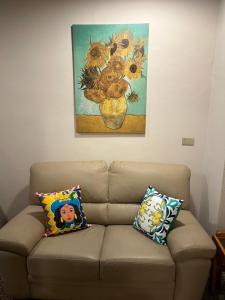 ミラノにあるApartment Suite Angelaの2つの枕とひまわりの絵が飾られたソファ +35枚の写真