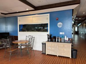 a room with a table and chairs and a blue wall at Georgian Inn Beach Club in Ormond Beach