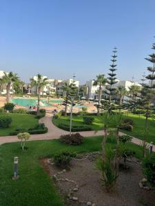 a park with a swimming pool and palm trees at Résidence Perla Saidia-seulement pour les familles- Plage à 5 min à pieds - Piscine en travaux in Saidia 