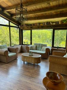a living room with couches and tables and windows at Casa Rural La Calera in San Millán de la Cogolla