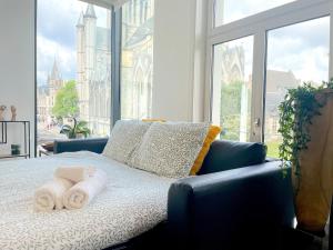 a bed with towels on it with a large window at Historic Centre Apartment - Ghent Belfry & St Nicholas Church View in Ghent