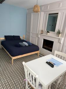 a bedroom with a bed and a table and a fireplace at Studio cosy équipé in Estevelles