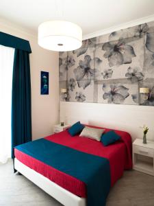 een slaapkamer met een rood en blauw bed en een muur bij Velvet Suite in Rome