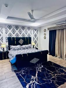 ラーワルピンディーにあるSunset Apartment Bahriaのベッドルーム1室(青いベッド1台、青いラグ付)