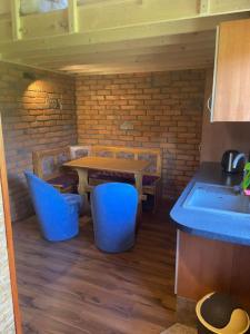 a kitchen with a table and some blue stools at Chatka nad stawem in Radłów +5 photos