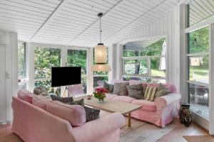 a living room with pink couches and a tv at 3077-Stege-Bundgarnet-137-B in Stege