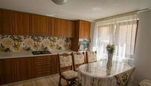 a kitchen with a table with chairs and a counter top at Casa Morarului in Bîrsana