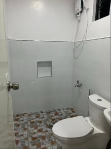 シキホールにあるJoRich Guest Houseのトイレとシャワー付きの白いバスルーム