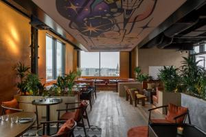 格拉斯哥The Social Hub Glasgow的有桌椅和大窗户的餐厅