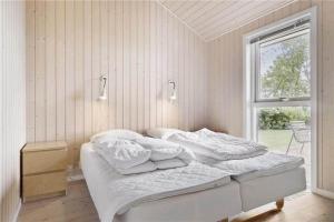 a white bedroom with a bed and a window at 8164-Praesto-Klintestien-16 in Præstø