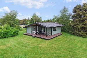 a small house with a deck in a yard at 1055-Stege-Rylevej-21 in Stege +8 photos