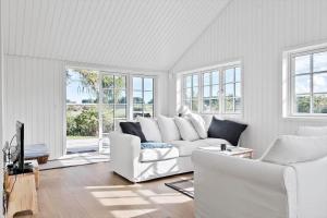 una sala de estar blanca con muebles y ventanas blancos. en 3011-Stege-Straektovet-18, en Stege
