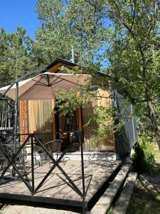 a house with an umbrella on a wooden deck at Sevanna Dream House in Tsamakaberd