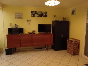 a living room with a black refrigerator and a cabinet at Studio charmant à Sarlat-la-Canéda avec terrasse in Sarlat-la-Canéda
