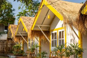 チャングーにあるSoleia Surf Camp Baliの茅葺き屋根の黄色いコテージ