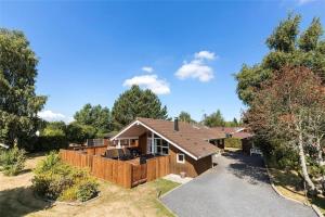 una casa con una recinzione in legno in un cortile di 3307-Stege-Maegleren-7 a Stege