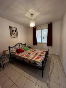 a bedroom with a bed and a window at Maison de vacances moderne et pratique : WiFi, clim, parking et cour privée in Canet-en-Roussillon