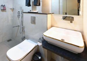 a bathroom with a sink and a toilet at Hotel Regency Grande in Trivandrum +16 photos
