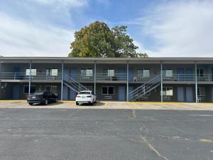 a building with two cars parked in a parking lot at Capri Motel By Belvilla Walla Walla US 12 in Walla Walla