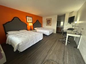 a hotel room with two beds and a desk at Capri Motel By Belvilla Walla Walla US 12 in Walla Walla