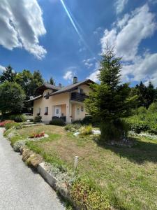 a house with a tree on the side of the road at Quiet Forest Retreat with Pool in Borovnica