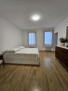 a bedroom with a bed and a dresser and two windows at Ca' San Valentino in Pontelongo +18 photos