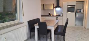a kitchen with a wooden table and black chairs at Privat Appartement R D-2 in Bruchköbel +12 photos