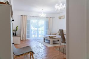 a living room with a couch and a table at appartement avec jardin privé dans une résidence hôtelière haut de gamme in Vilamoura