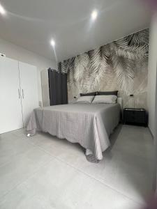 a bedroom with a bed and a wall with a mural at La Pola House Cagliari in Cagliari