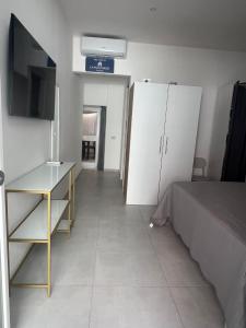 a bedroom with a bed and a table and cabinets at La Pola House Cagliari in Cagliari