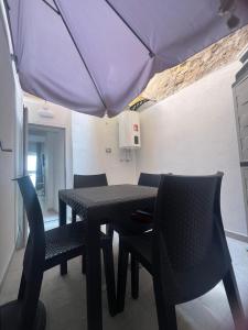 a table and chairs with an umbrella in a room at La Pola House Cagliari in Cagliari