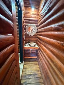 a bathroom in a log cabin with a sink in it at Cabaña Los Abuelos para 6 personas in Coronel Moldes +3 photos