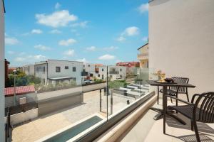 a balcony with a table and chairs on a building at Villa Ante Vodice in Vodice