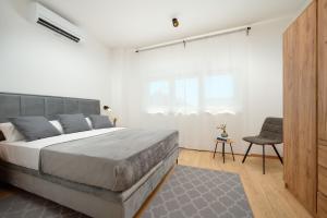 a bedroom with a large bed and a chair at Villa Ante Vodice in Vodice +46 photos