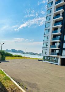 a parking lot in front of a tall building at Apartament 2 camere Mamaia Nord in Mamaia Nord