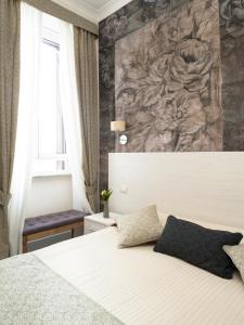 a bedroom with a large bed with a painting on the wall at Velvet Suite in Rome