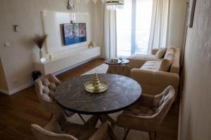 una sala de estar con una mesa y un sofá en Premium Planet Deluxe, en Niš