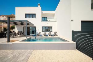 a swimming pool in the backyard of a house at Villa Ante Vodice in Vodice