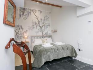 a white bedroom with a bed and a chair at Pippins in Ambleside